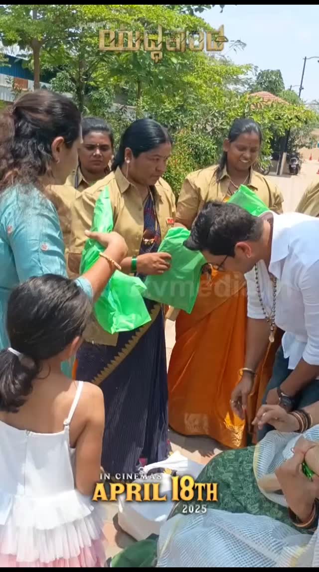 Ajay Rao distributes clothes from his daughter's hands