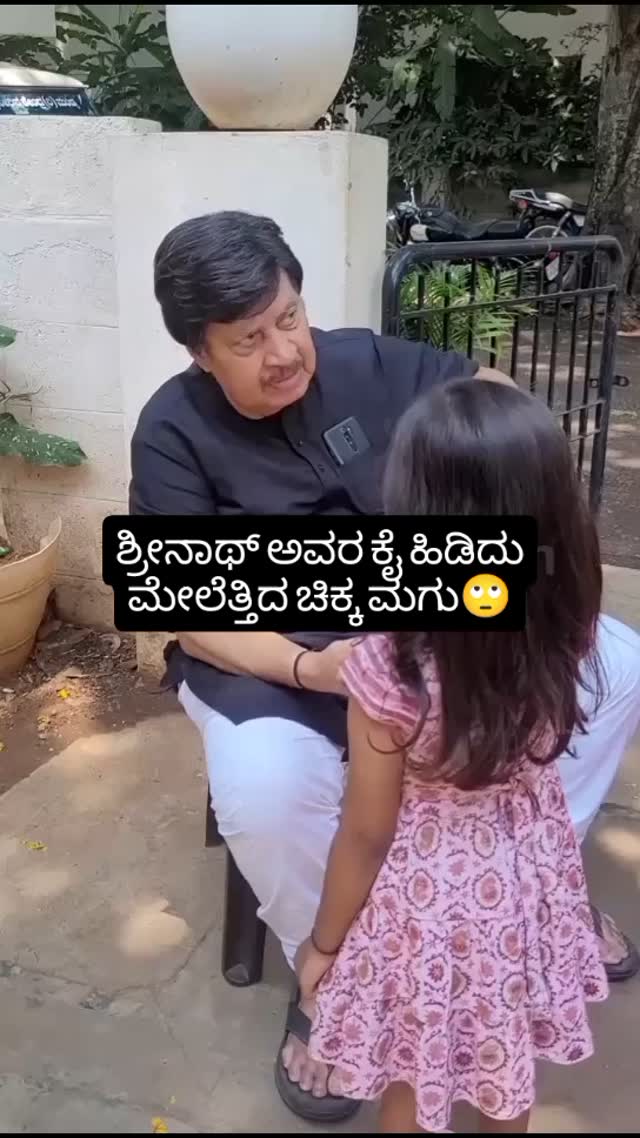 A small child holding Srinath's hand and lifting him up